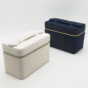 Two-tone fabric makeup boxes, white and navy, with gold zippers and top handles